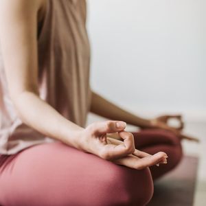 Person's hands in a meditative mudra pose.